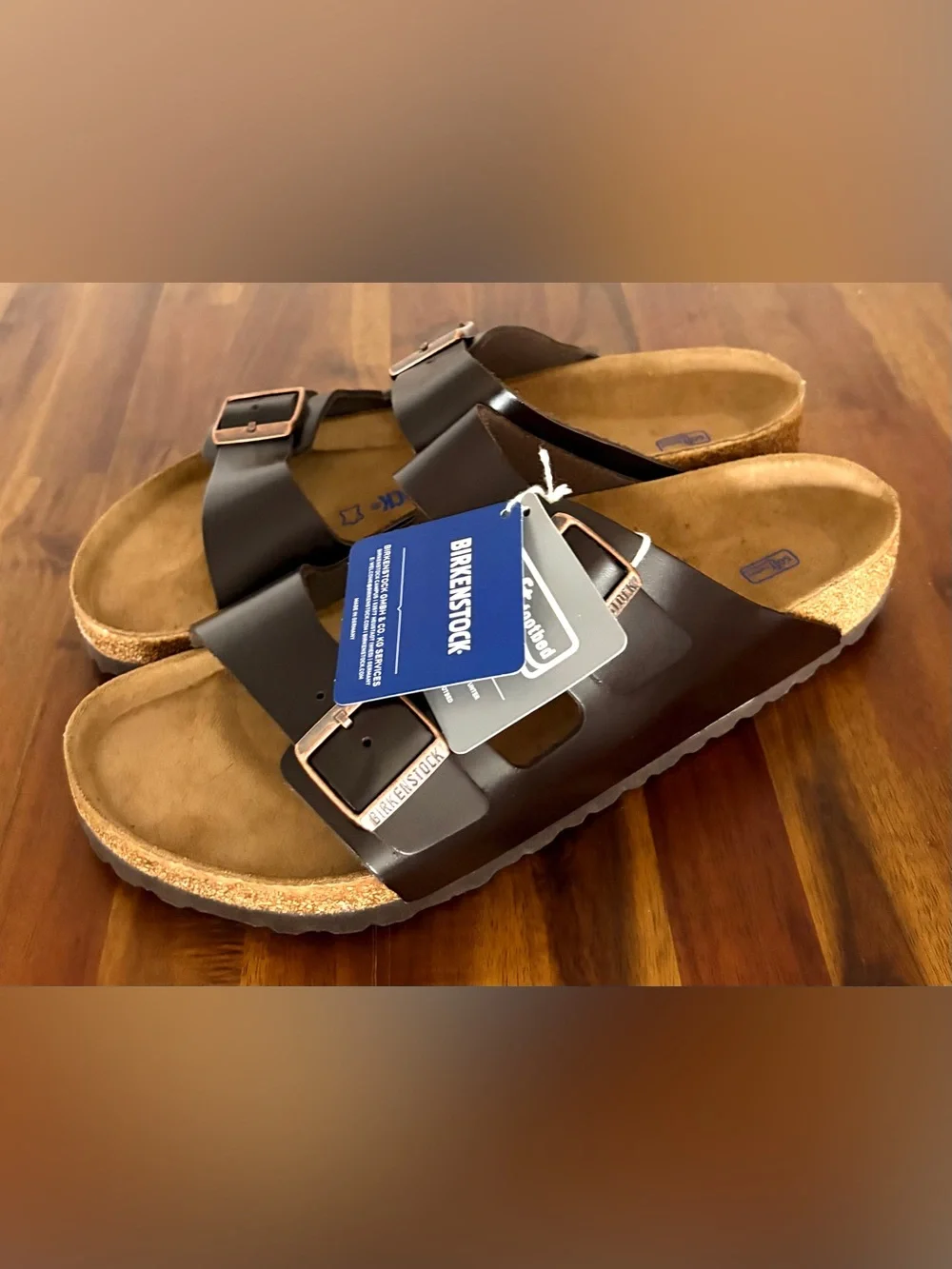 Birkenstock Men’s Arizona Two-Buckle Sandal — Dark Brown with Rose Gold Buckles.